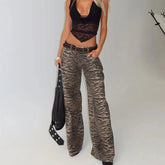 Person wearing zebra print pants and a black top on a plain background